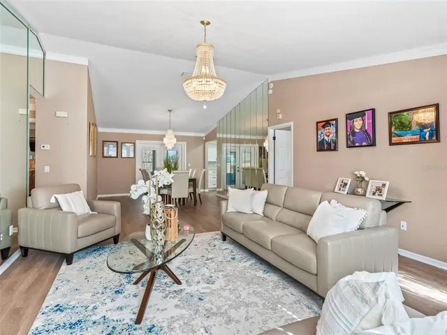 a living room with furniture kitchen view and a window