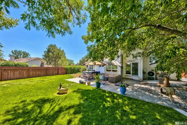 a backyard of a house with table and chairs