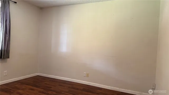 a view of a small space with wooden floor and a window
