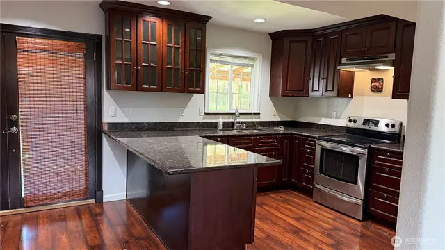 a kitchen with granite countertop a stove and a sink