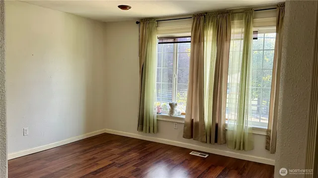 a view of a room with wooden floor and windows