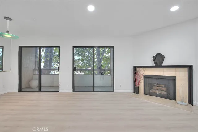 a view of an empty room with a fireplace and a window