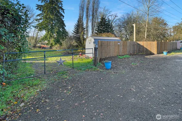 a view of backyard with wooden fence