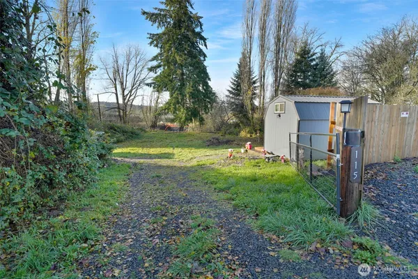 a view of a house with backyard and trees