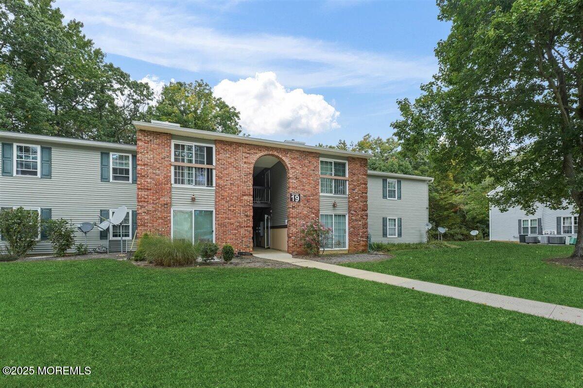 a backyard of a house with potted plants and large tree