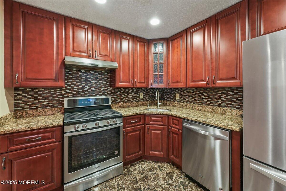 19 Augusta Court, Unit 8 Freehold, NJ 07728 - Photo 15 of 27 a kitchen with granite countertop wooden cabinets and stainless steel appliances