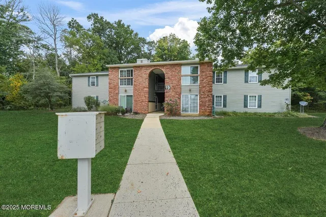 a front view of a house with a yard and trees