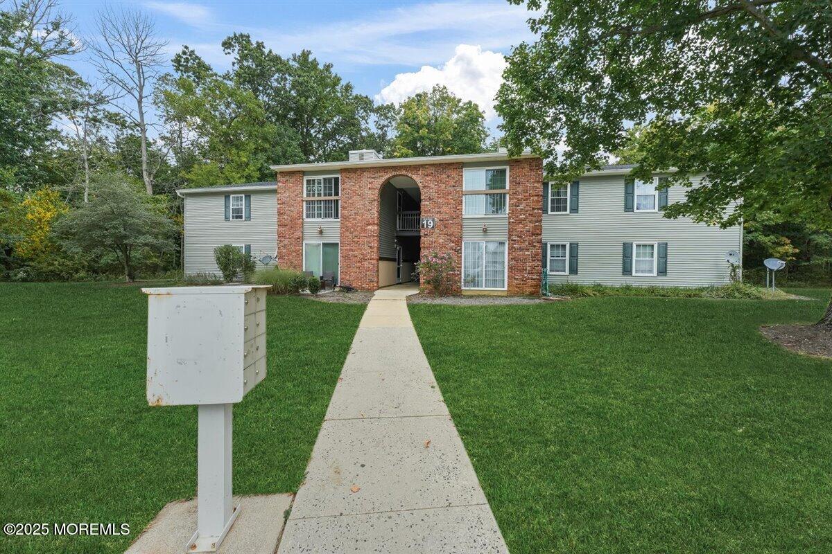 19 Augusta Court, Unit 8 Freehold, NJ 07728 - Photo 2 of 27 a front view of a house with a yard and trees
