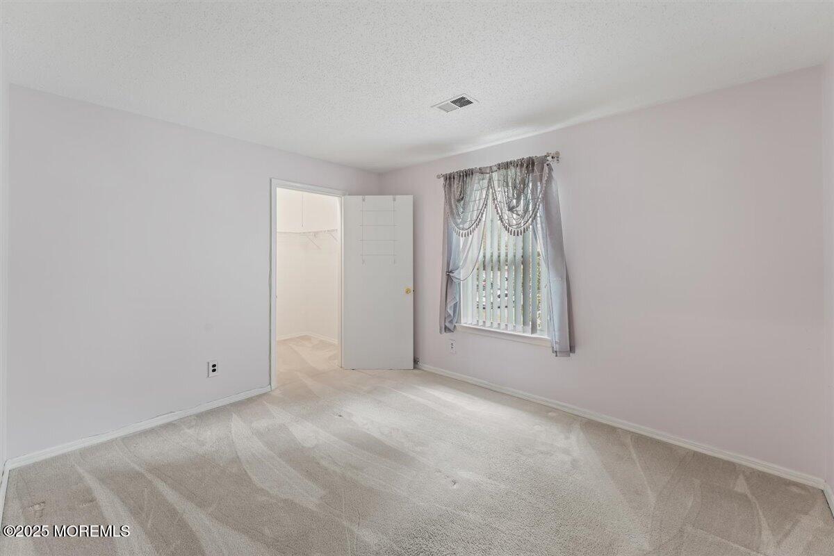 19 Augusta Court, Unit 8 Freehold, NJ 07728 - Photo 23 of 27 an empty room with windows