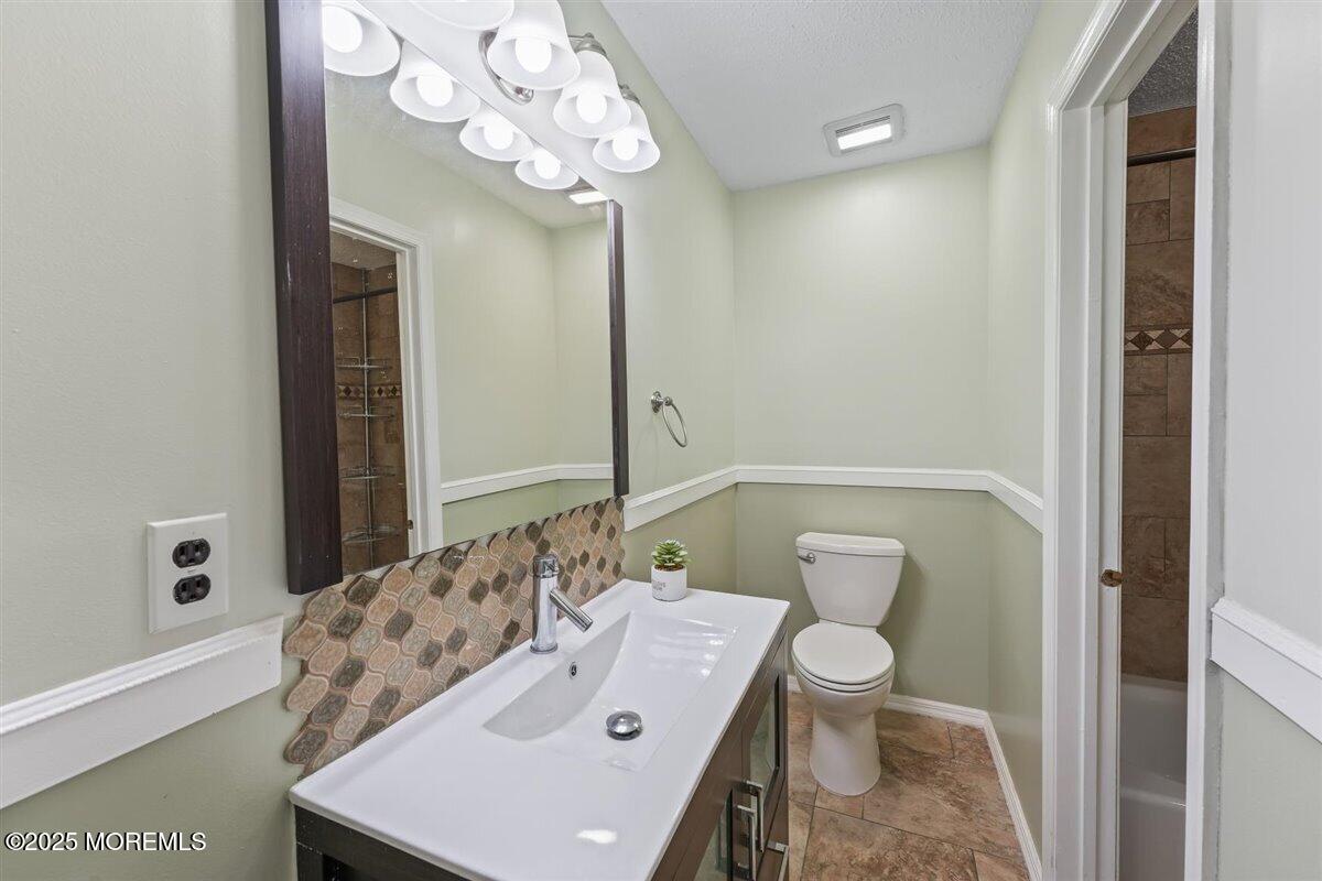 19 Augusta Court, Unit 8 Freehold, NJ 07728 - Photo 26 of 27 a bathroom with a toilet a sink and mirror
