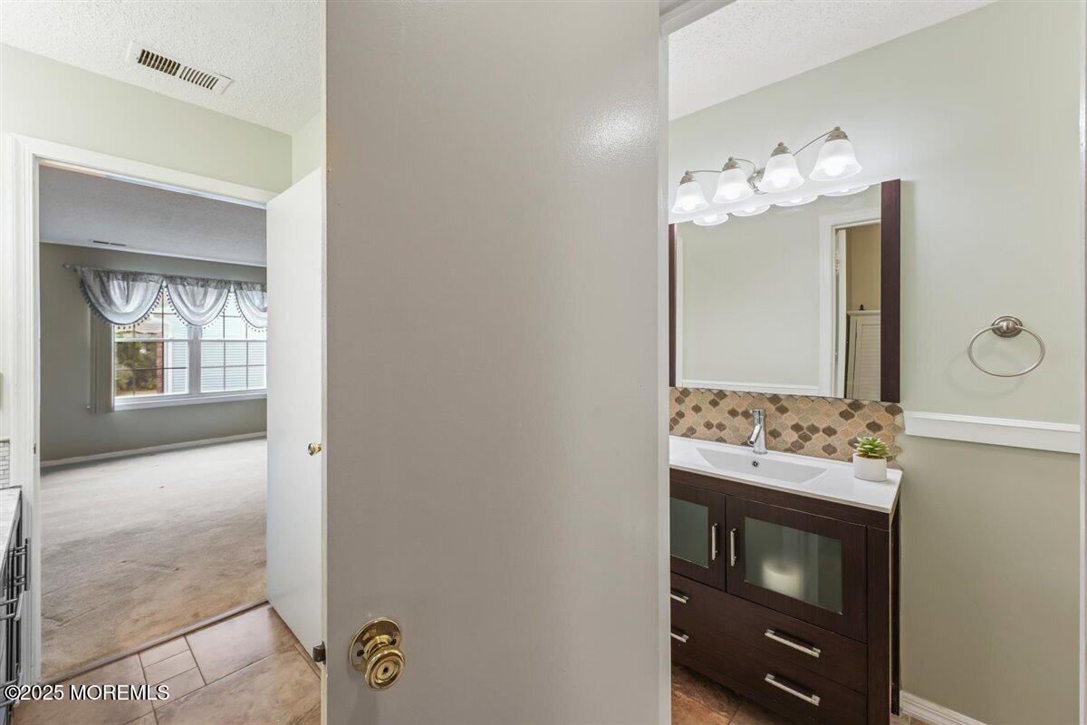 19 Augusta Court, Unit 8 Freehold, NJ 07728 - Photo 27 of 27 a bathroom with a sink vanity and a mirror