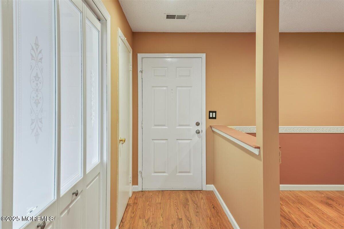 19 Augusta Court, Unit 8 Freehold, NJ 07728 - Photo 6 of 27 a view of a hallway with wooden floor and closet