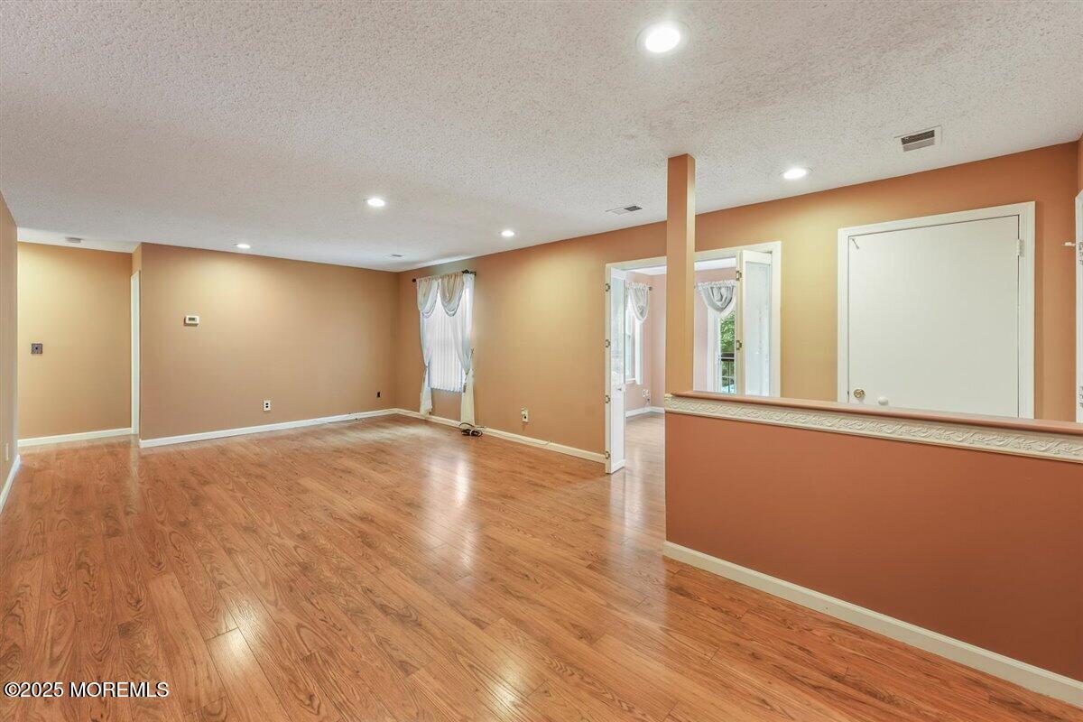19 Augusta Court, Unit 8 Freehold, NJ 07728 - Photo 7 of 27 a view of empty room with wooden floor and fan