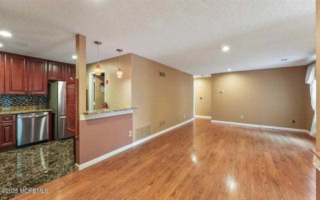 a view of a kitchen with a sink and a refrigerator