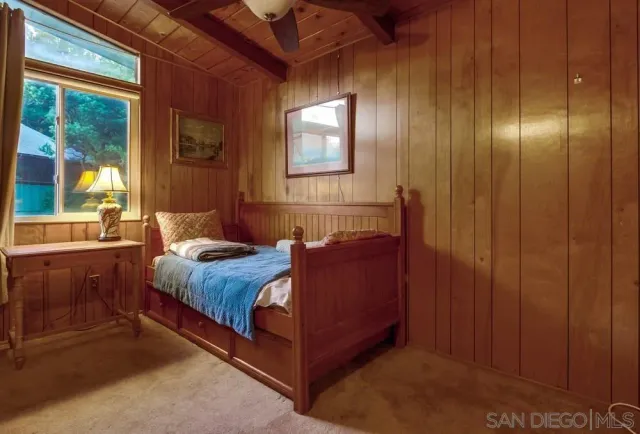 a bedroom with a bed and large windows