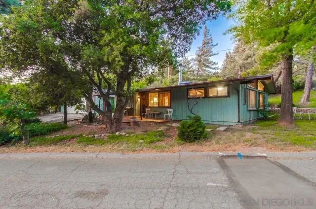 front view of a house with a yard and an trees