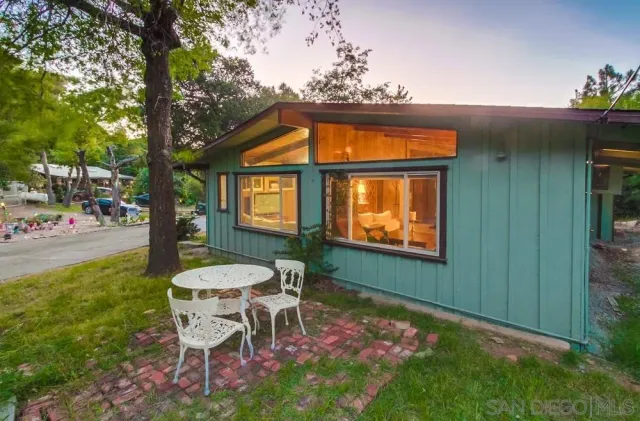 a patio with table and chairs and potted plants