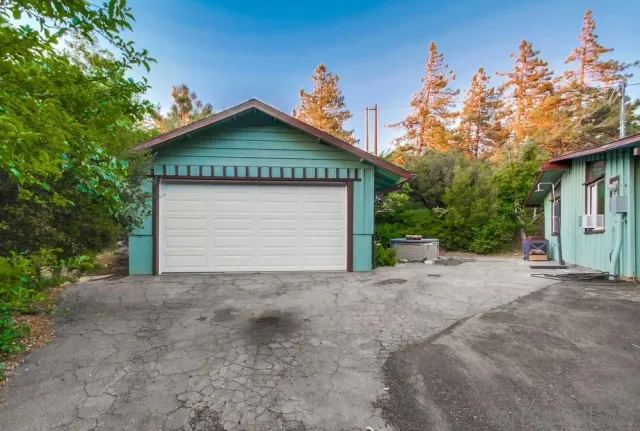 a view of a house with a small yard and a large tree