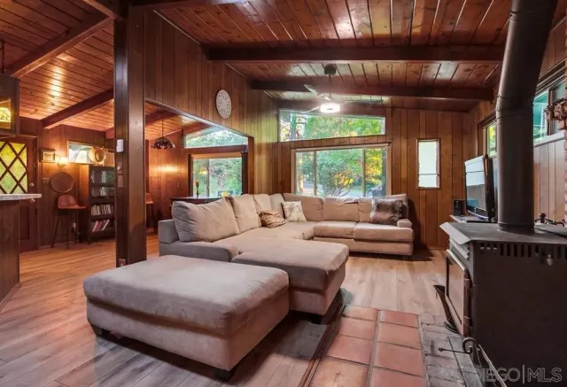 a living room with furniture a large window and a flat screen tv