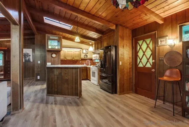a kitchen with stainless steel appliances granite countertop a refrigerator and wooden cabinets