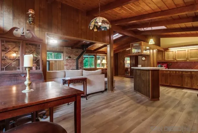 a living room with stainless steel appliances kitchen island granite countertop furniture and a large window