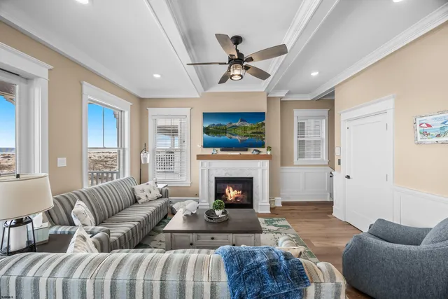 a living room with furniture a chandelier and a flat screen tv
