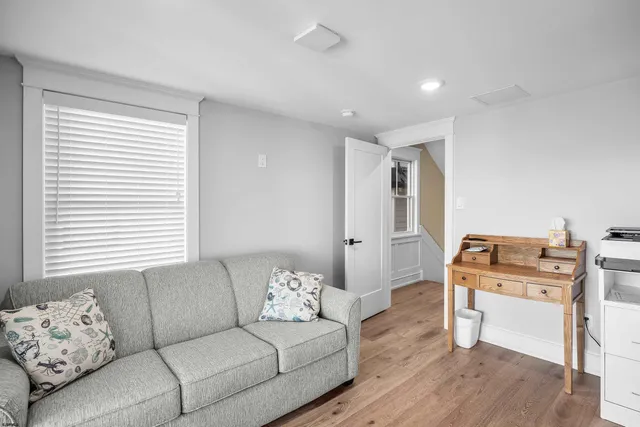 a living room with furniture kitchen view and a large window