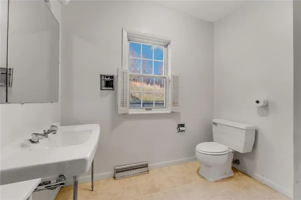 a bathroom with a sink toilet and a mirror
