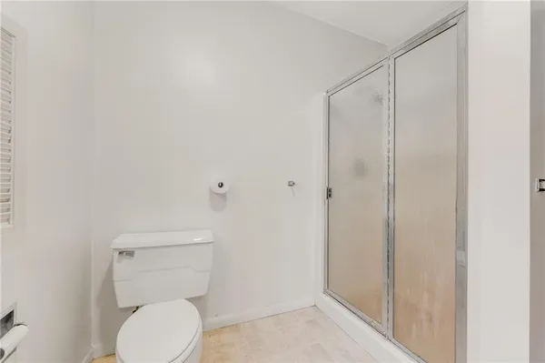 a white toilet sitting next to a shower