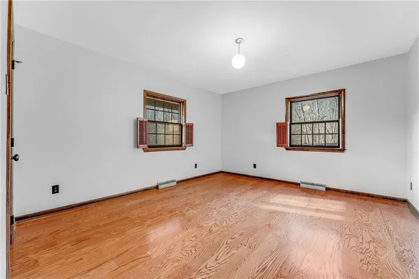an empty room with windows and wooden floor