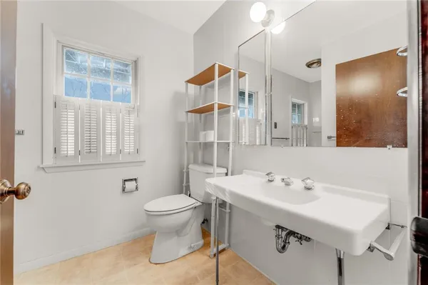 a bathroom with a sink mirror and toilet