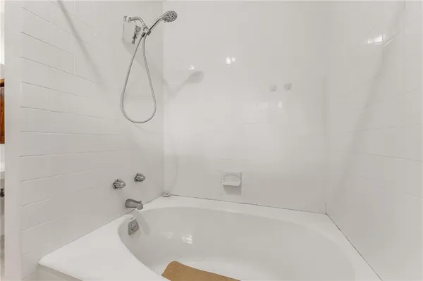 a bathroom with a white bath tub and a shower