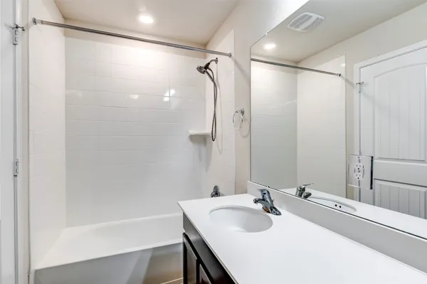 a bathroom with a tub sink and mirror