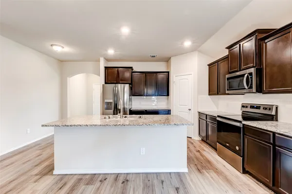 a large kitchen with stainless steel appliances and a sink