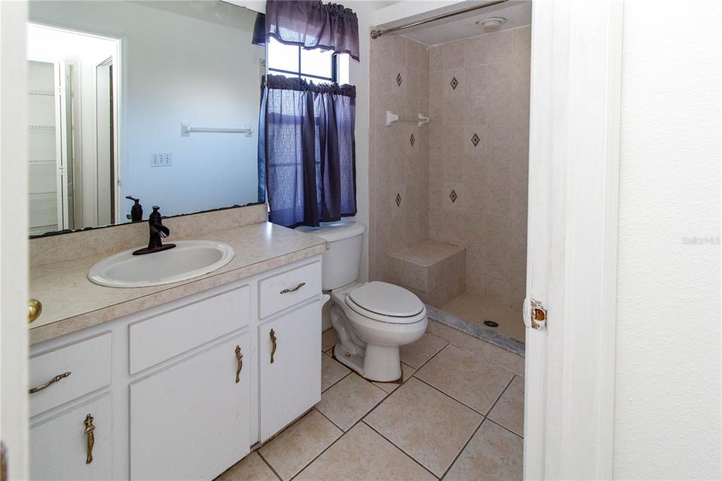 11339 Dean Street Spring Hill, FL 34608 - Photo 14 of 33 a bathroom with a toilet sink shower and mirror