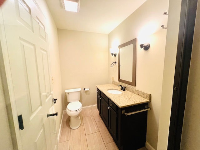 323 South Towanda Avenue, Unit 4 Normal, IL 61761 - Photo 16 of 33 a bathroom with a granite countertop sink a toilet and a mirror