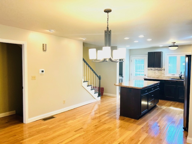 323 South Towanda Avenue, Unit 4 Normal, IL 61761 - Photo 6 of 33 a kitchen with stainless steel appliances kitchen island granite countertop a refrigerator a stove and a sink with wooden floor