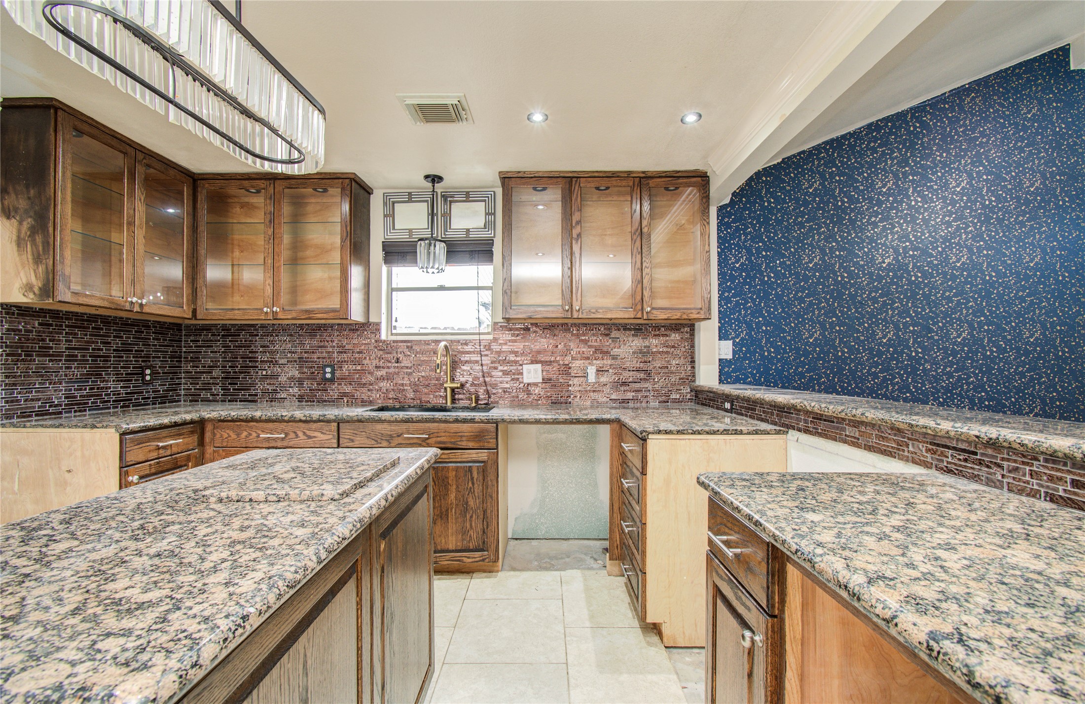 2006 Waterelm Drive Houston, TX 77084 - Photo 13 of 27 This kitchen boasts granite countertops, rich wood cabinetry, and a stylish backsplash, creating a warm and inviting space perfect for culinary adventures and entertaining.
