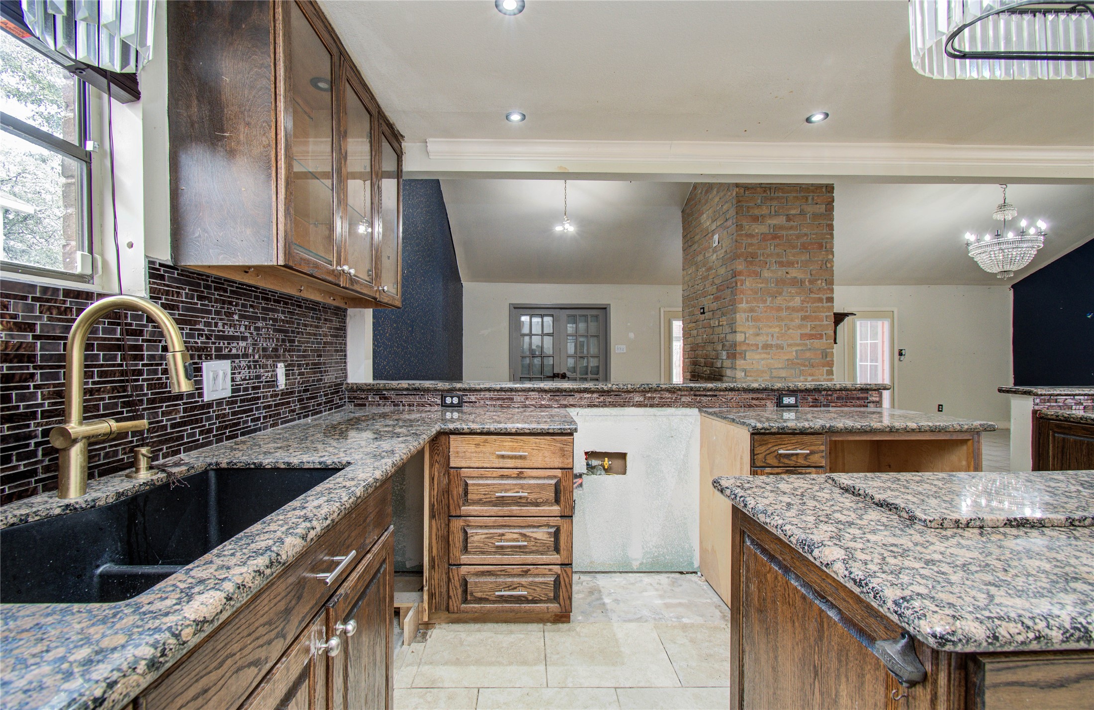 2006 Waterelm Drive Houston, TX 77084 - Photo 14 of 27 Discover the charm of this kitchen, featuring elegant granite countertops, rich wooden cabinetry, a sleek black sink, and a stylish backsplash, perfect for culinary creativity and entertaining.