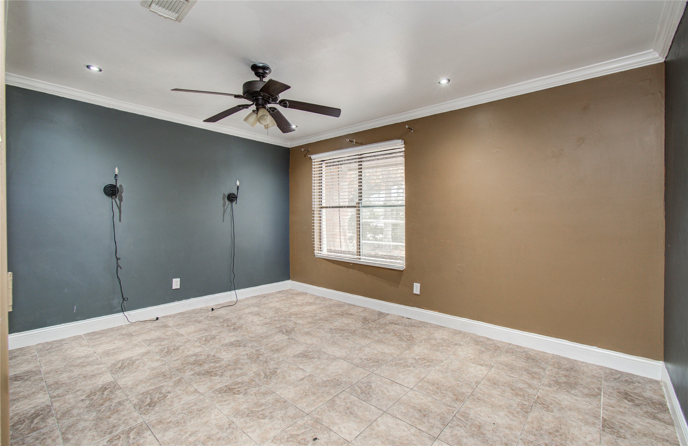 2006 Waterelm Drive Houston, TX 77084 - Photo 17 of 27 Discover a spacious and inviting bedroom with elegant tile flooring, a stylish ceiling fan, and abundant natural light streaming through large windows, offering a serene retreat.