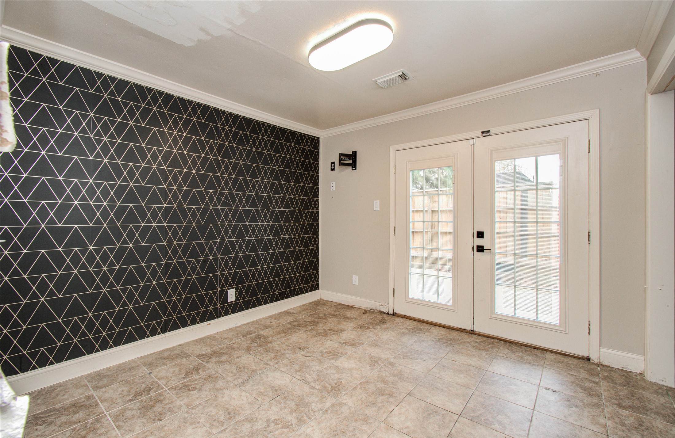2006 Waterelm Drive Houston, TX 77084 - Photo 19 of 27 This stylish bedroom features a striking geometric accent wall and elegant French doors, offering a blend of modern design and natural light.
