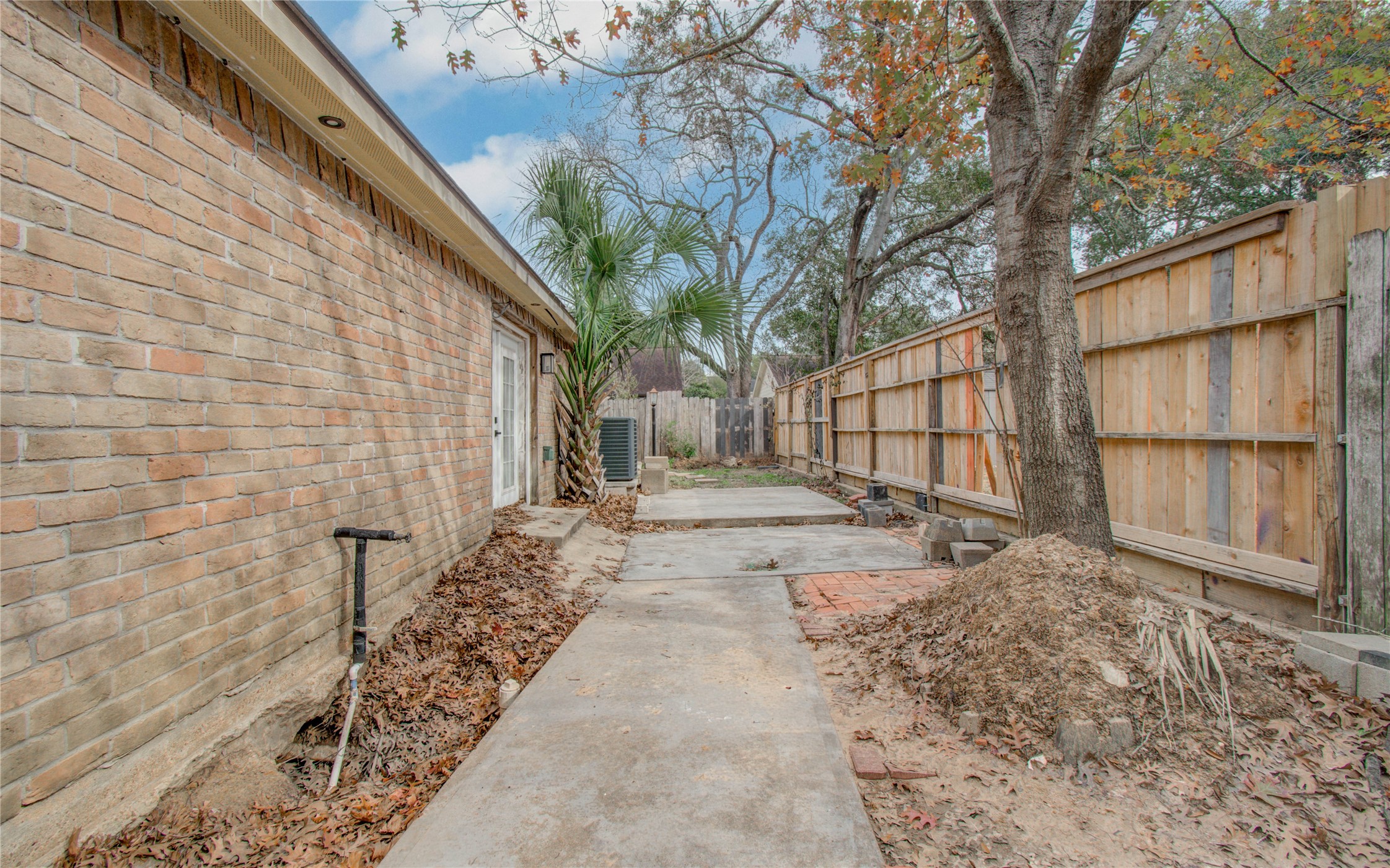 2006 Waterelm Drive Houston, TX 77084 - Photo 24 of 27 Discover the potential of this inviting side yard, offering a serene pathway with mature trees and privacy fencing—perfect for your outdoor sanctuary or garden retreat.