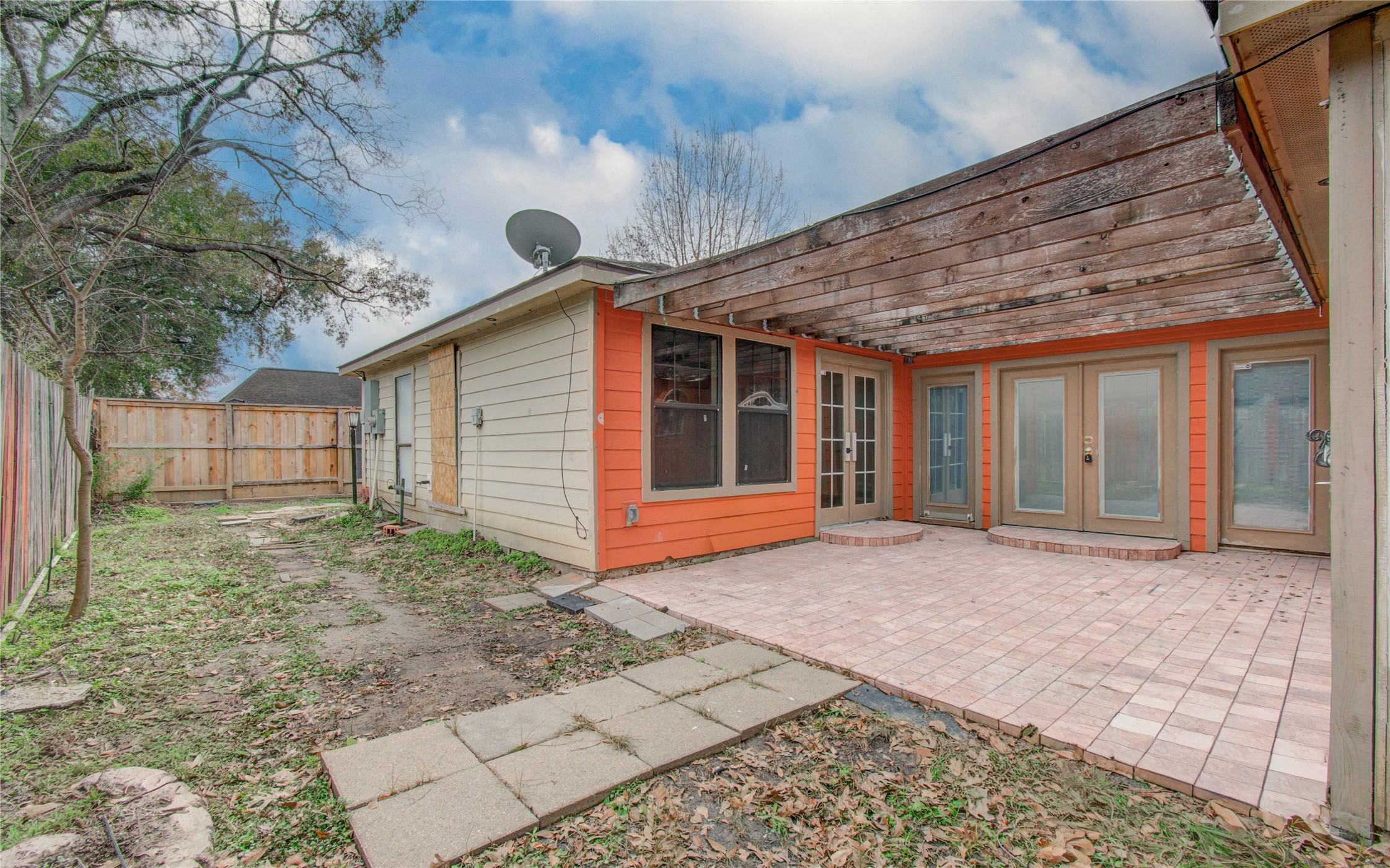 2006 Waterelm Drive Houston, TX 77084 - Photo 26 of 27 This backyard patio offers a charming and versatile outdoor space, perfect for relaxation and entertaining, with a rustic pergola and a seamless blend of nature and comfort.