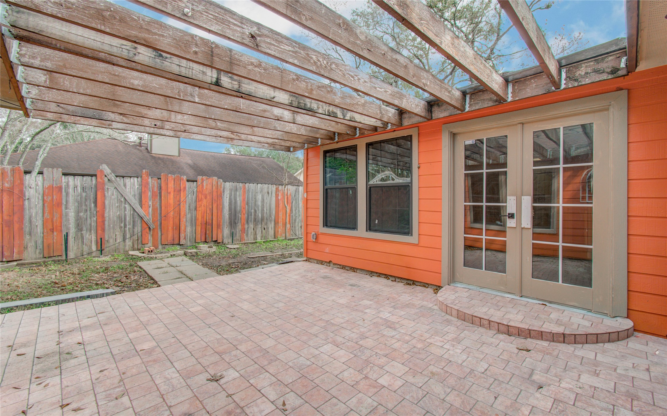 2006 Waterelm Drive Houston, TX 77084 - Photo 27 of 27 Step into your serene retreat with this inviting backyard patio, featuring a charming pergola and elegant French doors, perfect for effortless outdoor living and entertaining.