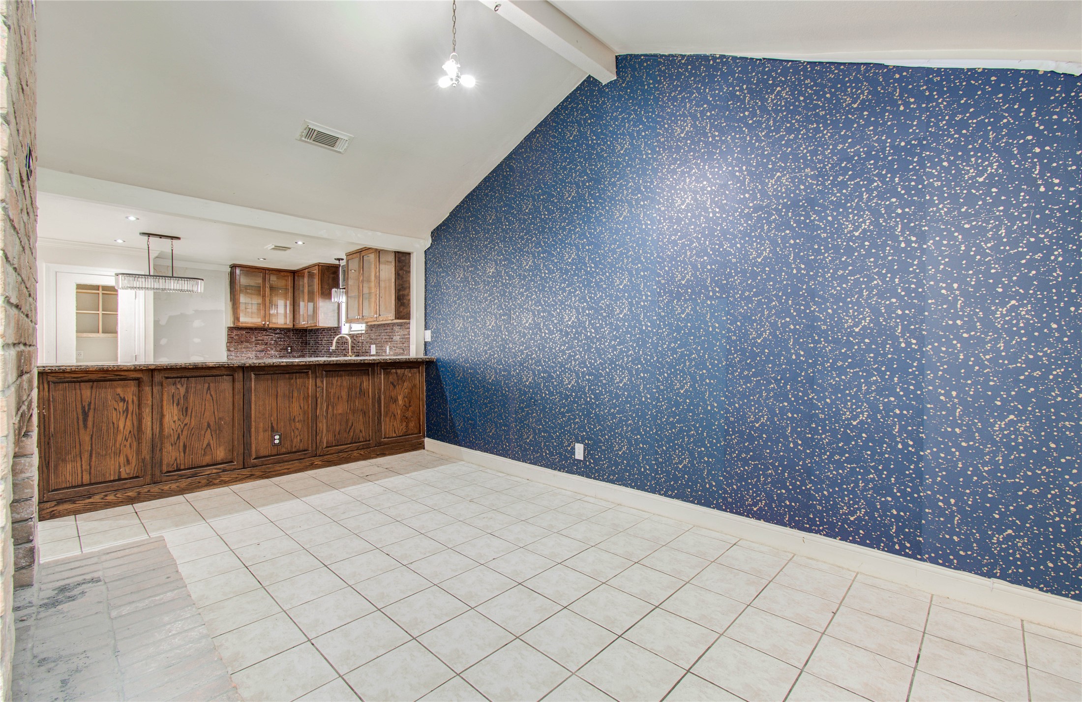 2006 Waterelm Drive Houston, TX 77084 - Photo 6 of 27 This dining room offers a captivating blend of elegance and warmth, featuring a stylish accent wall, vaulted ceilings, and convenient access to the kitchen through a rustic wooden counter.