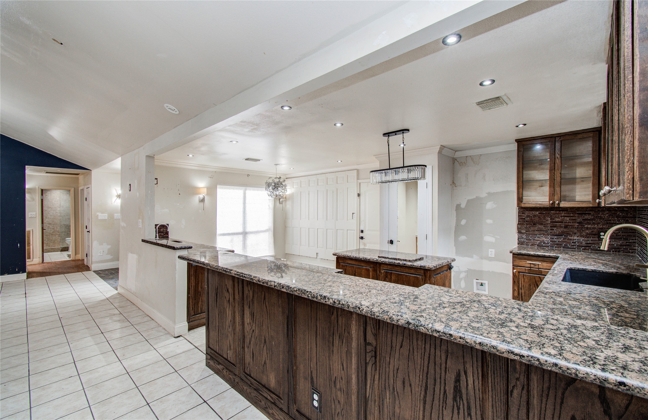 2006 Waterelm Drive Houston, TX 77084 - Photo 8 of 27 This spacious kitchen boasts elegant granite countertops, rich wooden cabinetry, and modern lighting, creating an inviting space perfect for culinary adventures and entertaining.