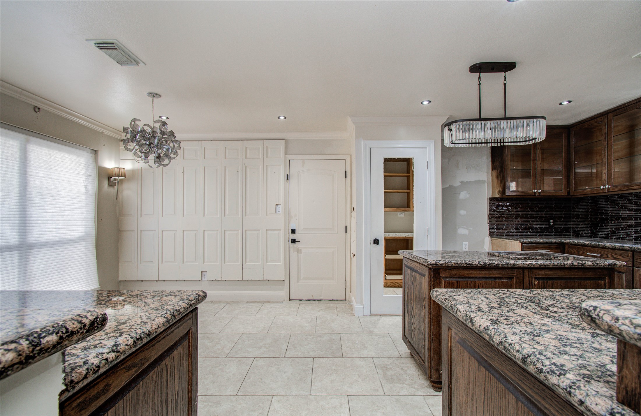 2006 Waterelm Drive Houston, TX 77084 - Photo 9 of 27 This inviting kitchen features elegant granite countertops, rich wooden cabinetry, and a chic chandelier, creating a perfect blend of style and functionality.