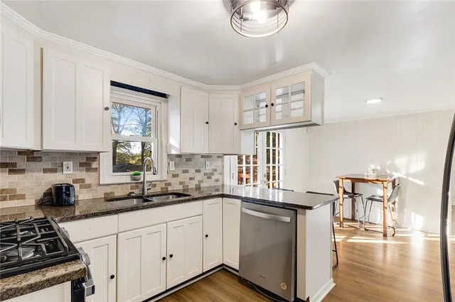 a kitchen with stainless steel appliances granite countertop a sink stove and cabinets