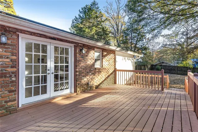 a view of backyard with large trees and wooden floor