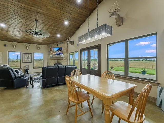 a dining room with stainless steel appliances kitchen island granite countertop a table and chairs